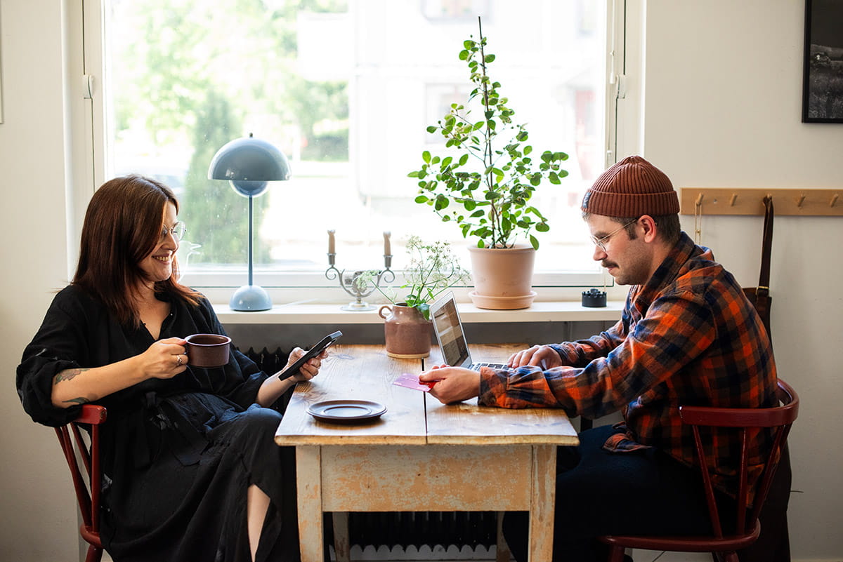 a couple using a payment card sat at the dining table