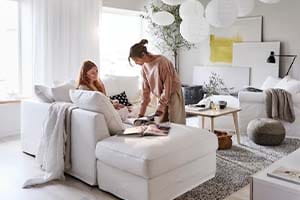 Two women in a lounge sitting on a white sofa